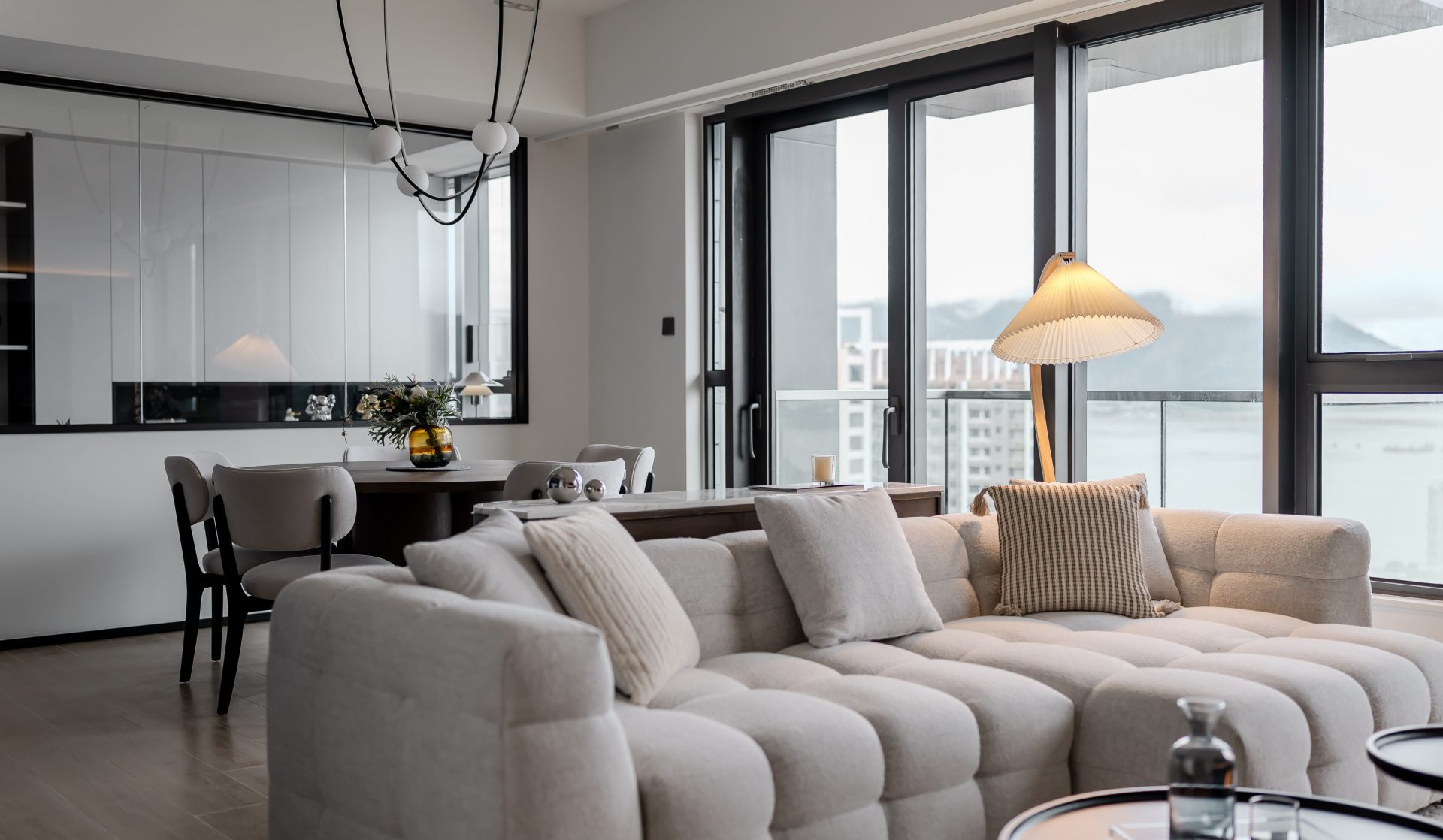 Double Cove — white modular sofa connecting the dining area with full-height windows