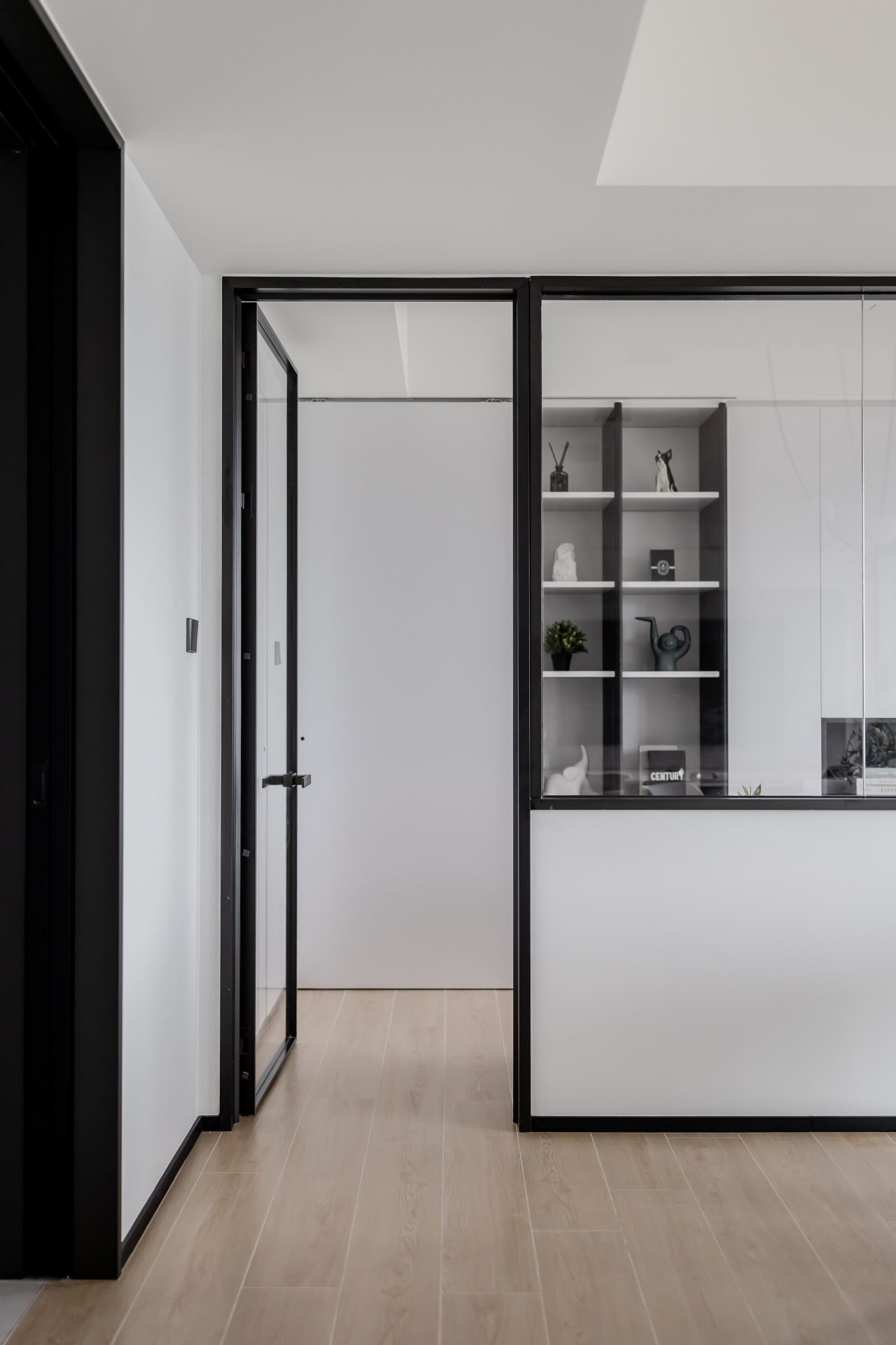 Double Cove — built-in display shelving beside a black-framed glazed door
