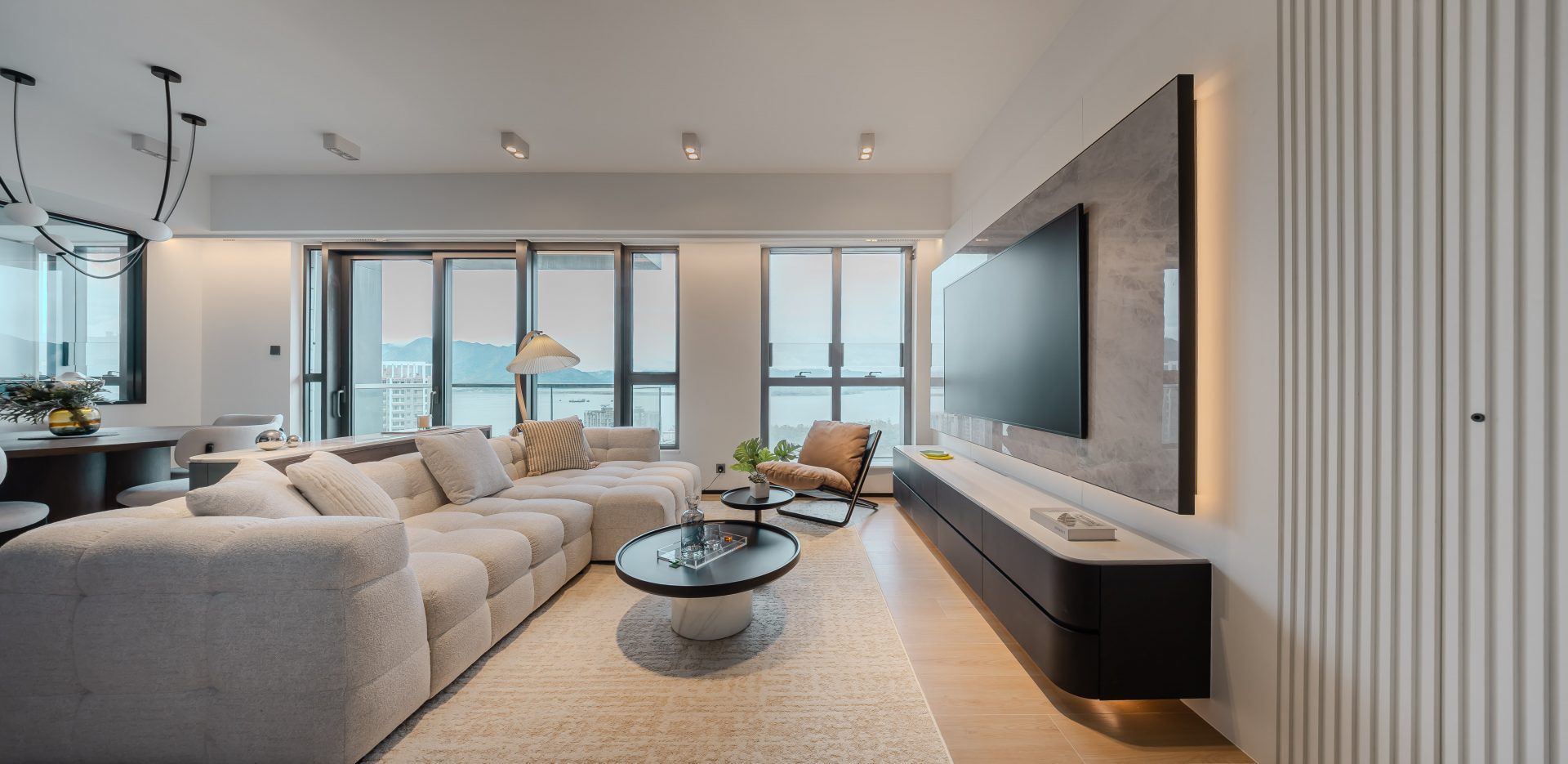 Double Cove — white sofa, stone TV wall and waterfront windows