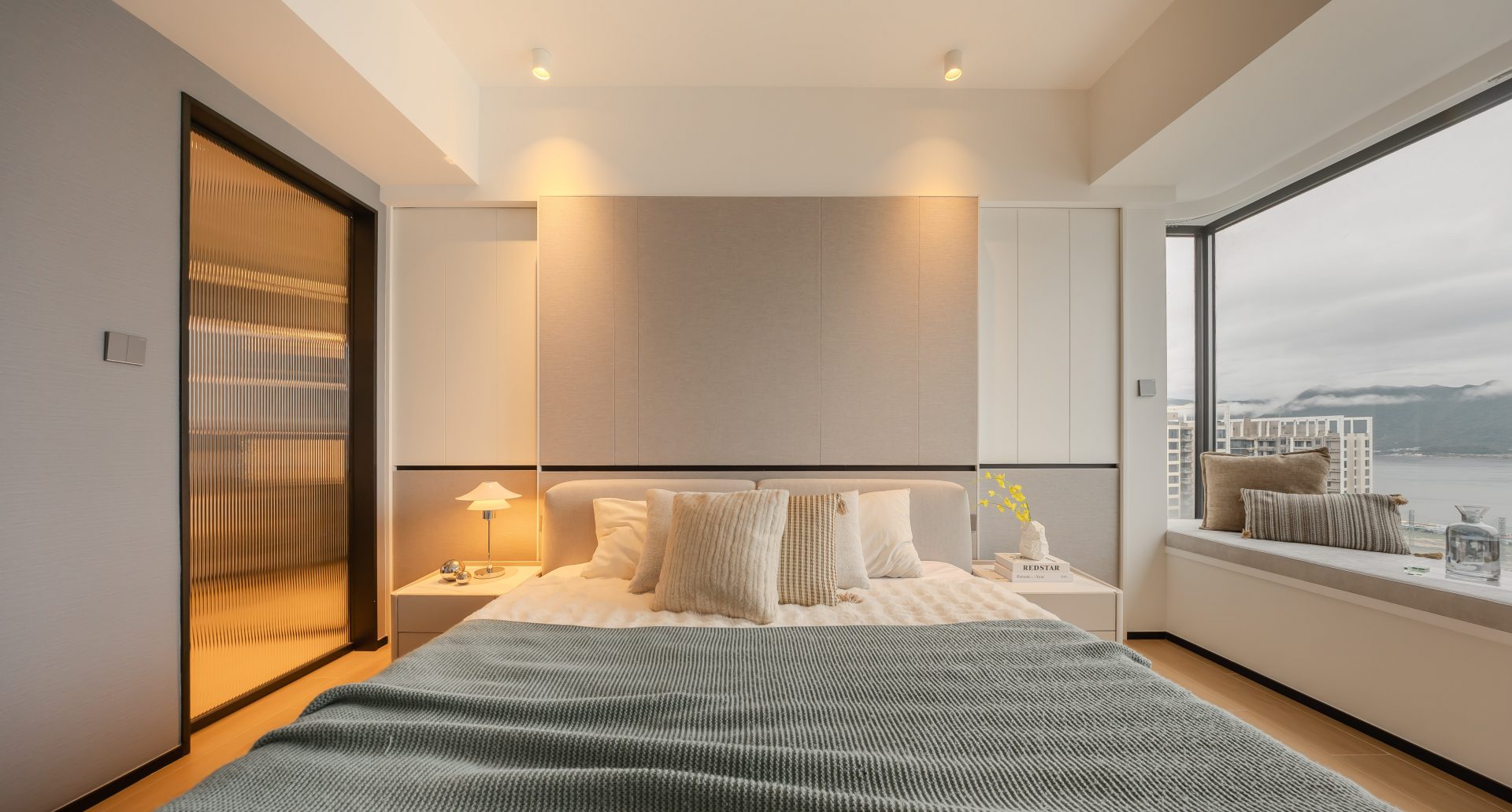 Double Cove — bedroom with an upholstered bed, timber trim and window bay