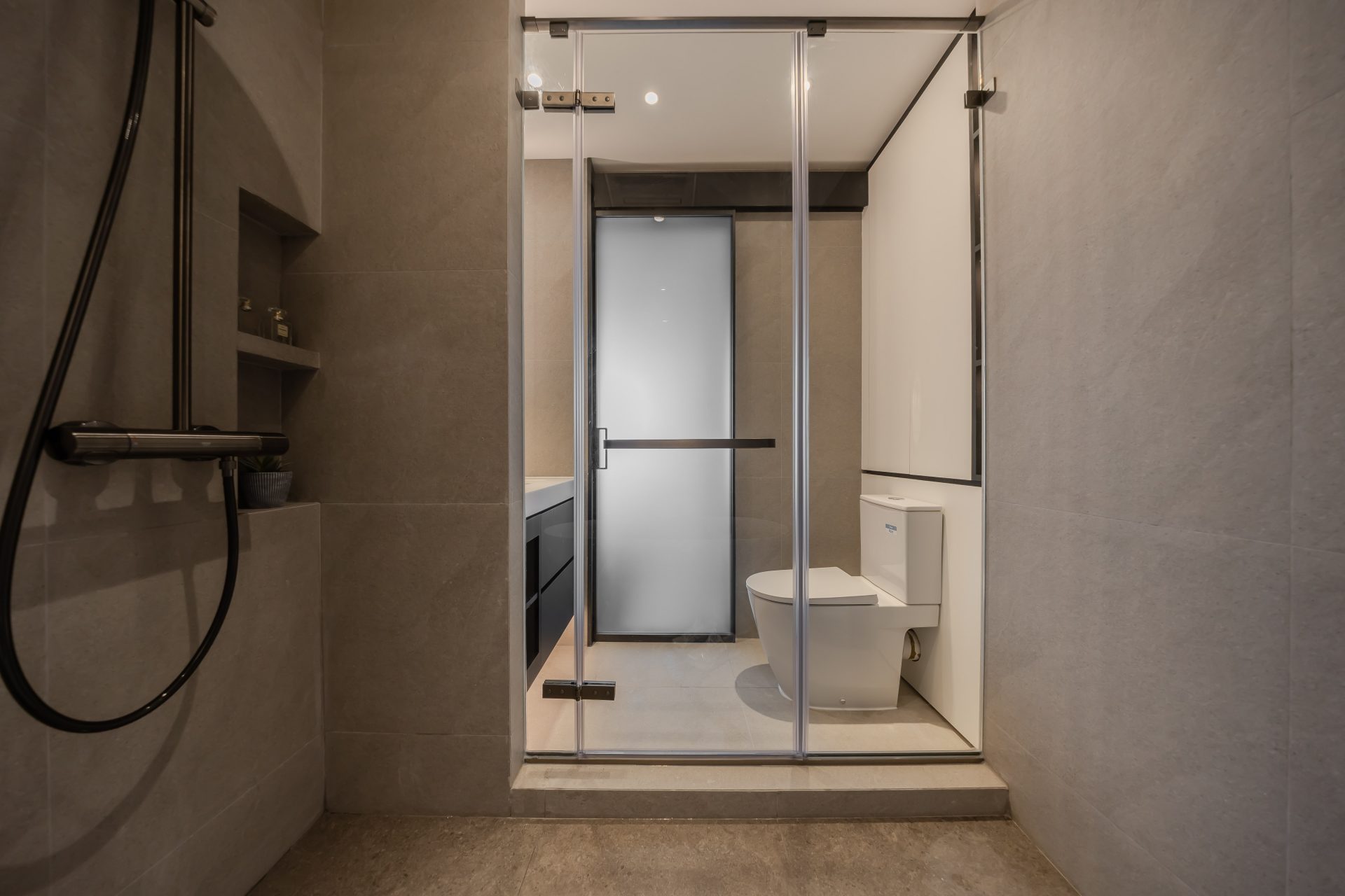 Double Cove — neutral bathroom passage leading to a glass shower enclosure