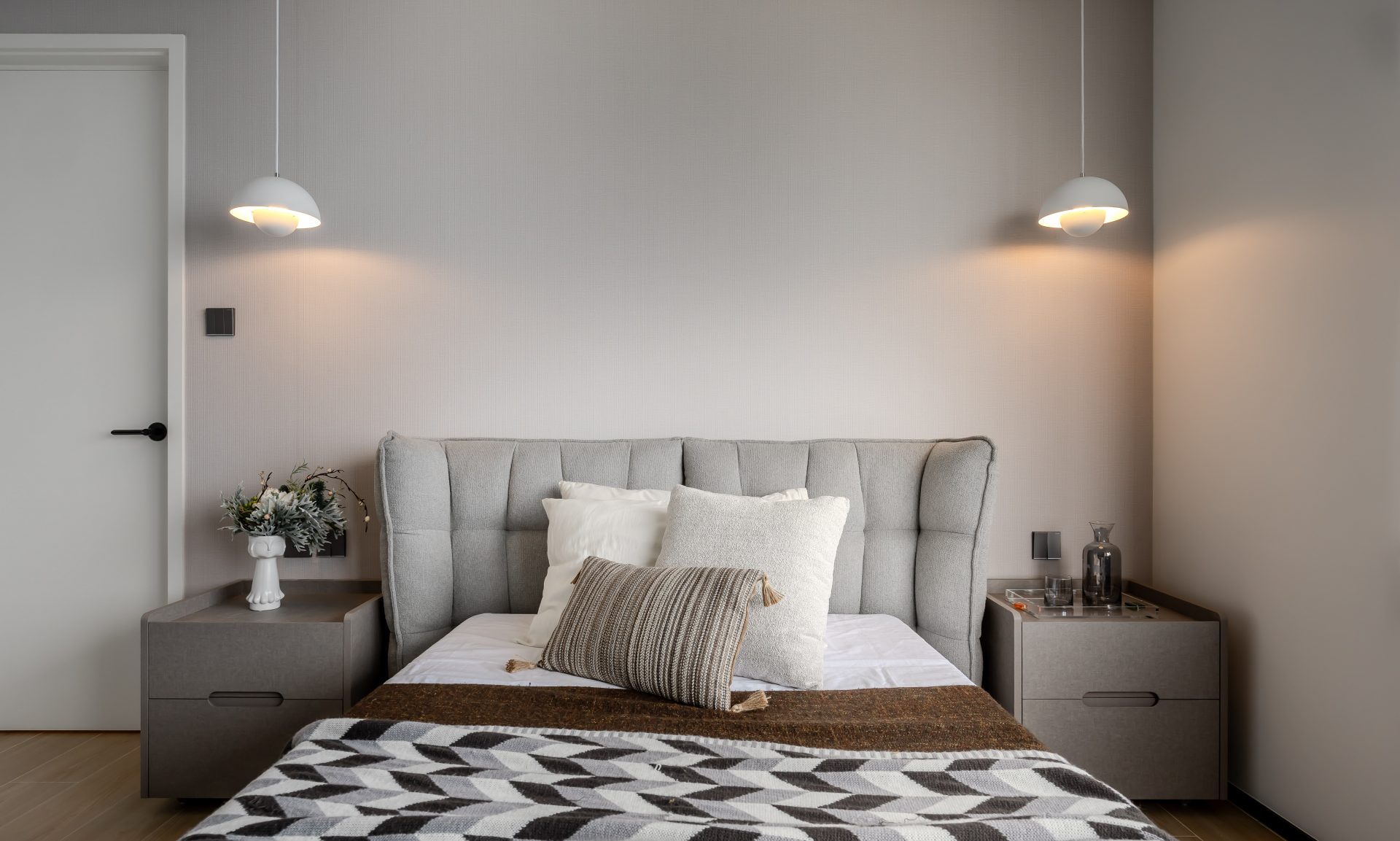 Double Cove — upholstered bed with twin pendant lights and a neutral headboard wall