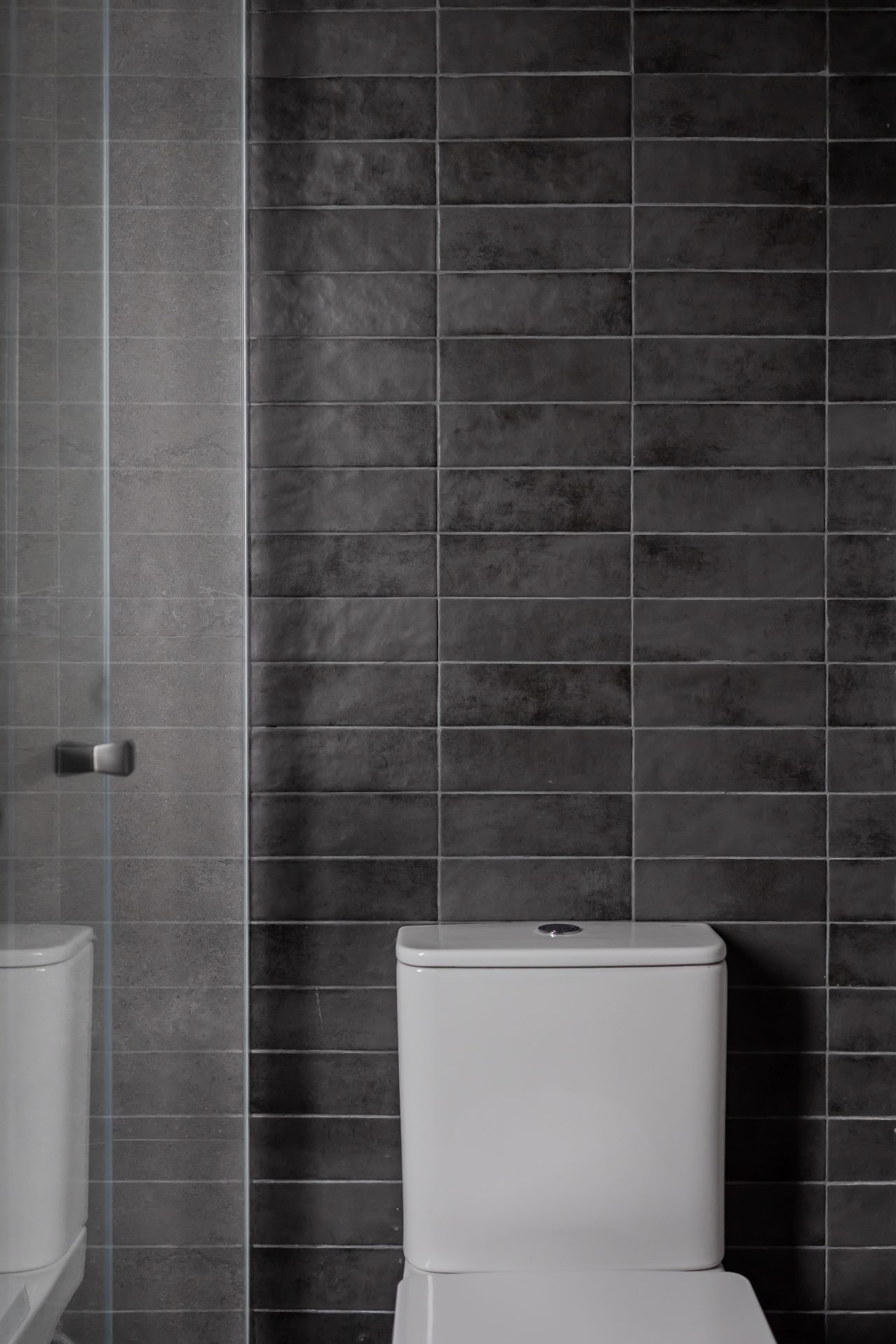 Double Cove — dark grey tiled bathtub wall with a hand shower